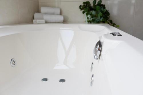 eine weiße Badewanne im Bad mit Pflanze in der Unterkunft Moeke Mooren in Appeltern