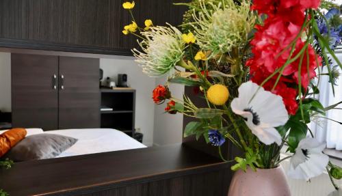 a vase filled with flowers on a table in a bedroom at Moeke Mooren in Appeltern