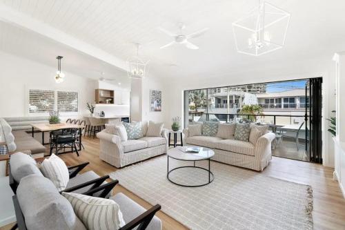 a living room with couches and a dining room at Budds Villa 1 By Khove in Gold Coast