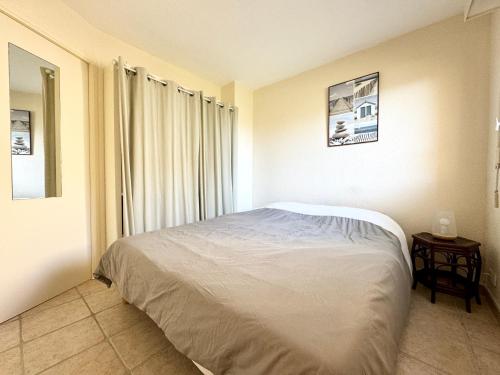 ein Schlafzimmer mit einem Bett und einem Tisch darin in der Unterkunft Joli appartement cosy – Terrasse face à la mer in Ploemeur