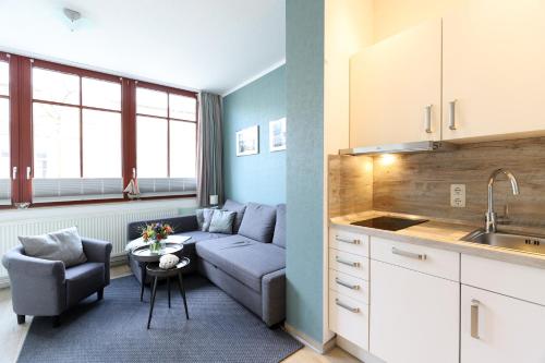 mały salon z kanapą i kuchnią w obiekcie Appartementhaus Strandnähe w mieście Warnemünde