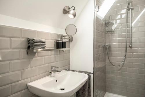a white bathroom with a sink and a shower at Ferienwohnung Burgstübchen in Nordhorn