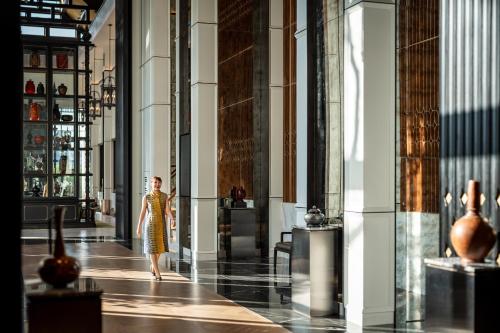 a woman walking down a hallway in a building at InterContinental Chiang Mai The Mae Ping in Chiang Mai