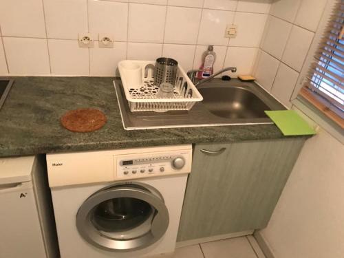 une cuisine avec une machine à laver et un évier dans l'établissement appartement, à Toulouse