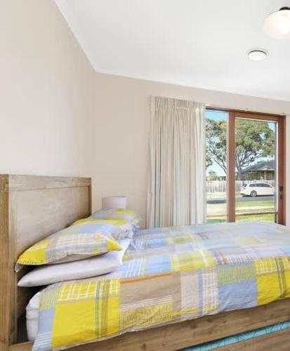 a bedroom with a bed and a window at Coastal Days - pet friendly retreat near parks, shops and beaches in Torquay