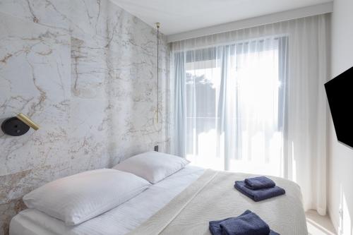 a bedroom with a bed with two towels on it at HEVENIA POGORZELICA - APARTAMENT 2 in Pogorzelica