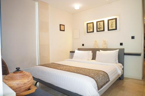 a bedroom with a large bed with white pillows at FuramaXclusive Ocean Beach Seminyak Bali in Legian