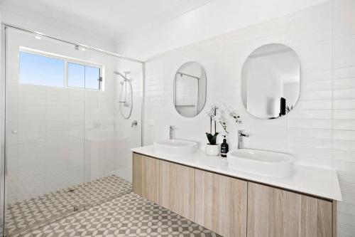 een witte badkamer met 2 wastafels en een douche bij Seaspray Ocean View Retreat in Torquay