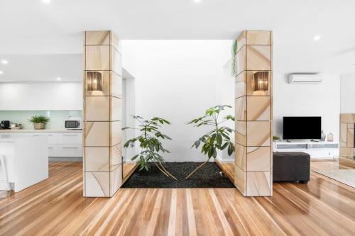 a living room with two potted plants at Luxury Torquay Townhouse 150m to Beach in Torquay