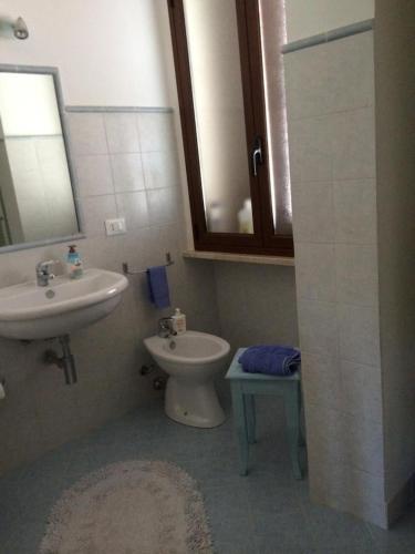 a bathroom with a sink and a toilet and a mirror at Subito in Centro in Favignana