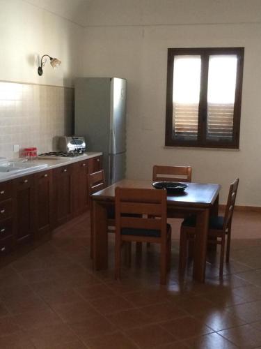 a kitchen with a table and chairs and a refrigerator at Subito in Centro in Favignana