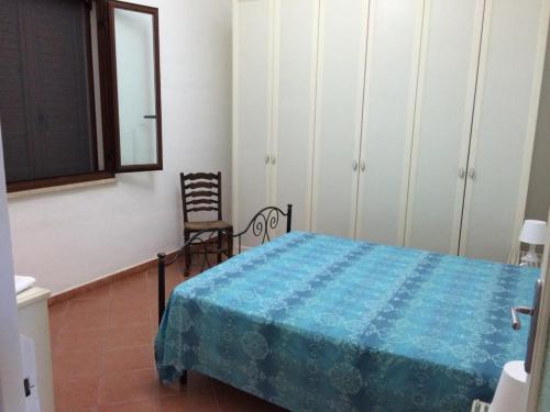 ein Schlafzimmer mit einem Bett, einem Stuhl und einem Spiegel in der Unterkunft Subito in Centro in Favignana