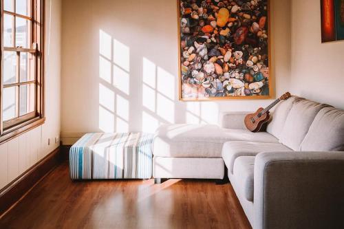 a living room with a couch and a guitar at Sunset Cottage By The Bay Pet Friendly in Portarlington
