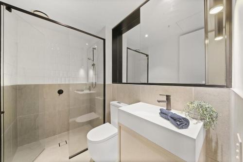 W łazience znajduje się toaleta, umywalka i prysznic. w obiekcie A Stylish & Cozy 2BR Apt Near Melbourne Central w Melbourne