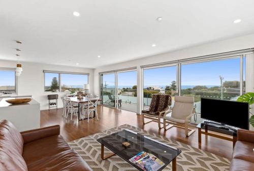 una sala de estar con un sofá y una mesa en Penthouse Spectacular Ocean Views From Every Room, en Ocean Grove