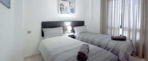 Dos camas en un dormitorio con una persona sobre ellas en 5 Campoamor Golf, en Campoamor