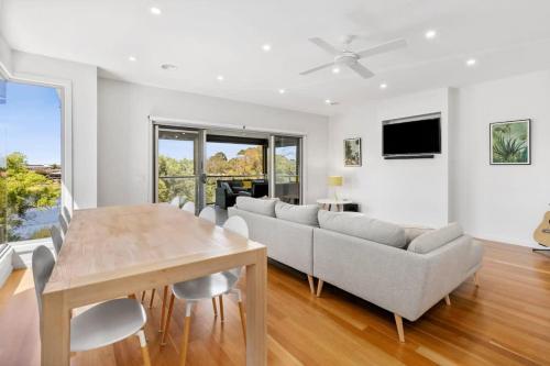 a living room with a couch and a table at Riviera Lakeside with uninterrupted Water Views in Ocean Grove
