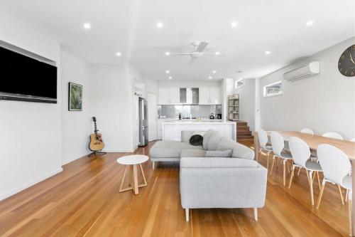 a living room with a couch and a table at Riviera Lakeside with uninterrupted Water Views in Ocean Grove