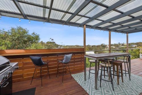 a patio with a table and chairs on a deck at Happy Place of Light and Water Views in Jan Juc in Torquay