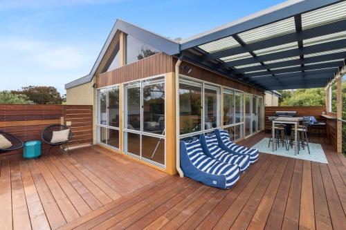a covered deck with a table and chairs on it at Happy Place of Light and Water Views in Jan Juc in Torquay