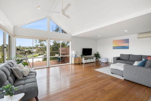 a living room with two couches and a television at Happy Place of Light and Water Views in Jan Juc in Torquay