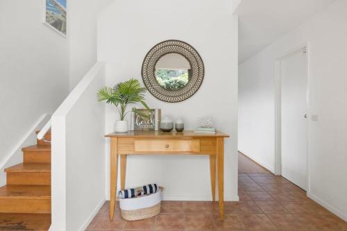 a console table in a hallway with a mirror at Happy Place of Light and Water Views in Jan Juc in Torquay