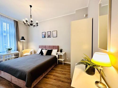 a bedroom with a bed and a desk and a lamp at Studio przy Placu Jasia Rybaka in Sopot