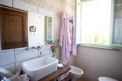 a bathroom with a sink and a toilet and a window at Locanda Antico Casale Cesenatico in Cesenatico