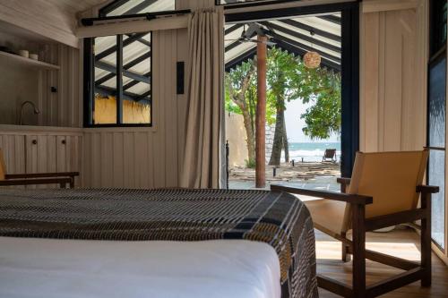 a bedroom with a bed and a view of the ocean at Ocean front cabin in Madiha in Kamburugamuwa
