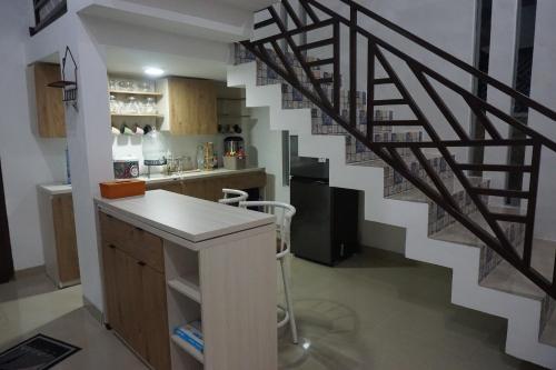 uma cozinha com uma escada em espiral numa casa em d’Viella Lampung em Kedaton