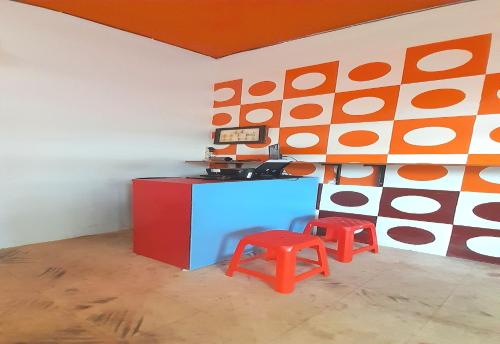 a room with two red stools next to a wall at SPOT ON 93852 Fermansio Homestay 2 in Medan