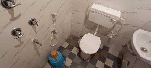 La salle de bains est pourvue de toilettes blanches et d'un lavabo. dans l'établissement Hotel Ocean Bird, 