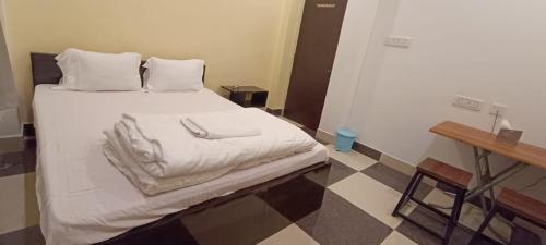 - une chambre avec un lit doté de draps et d'oreillers blancs dans l'établissement Hotel Ocean Bird, 
