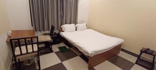 Cette petite chambre comprend un lit, une table et des chaises. dans l'établissement Hotel Ocean Bird, 