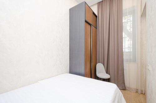 a bedroom with a white bed and a chair at 15. Double room apartaments with fresh style in Yerevan