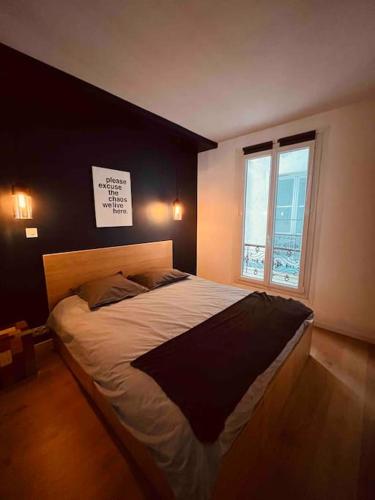 une chambre avec un grand lit avec une fenêtre dans l'établissement Appartement Cosy 1 bedroom Levallois-Perret, à Levallois-Perret
