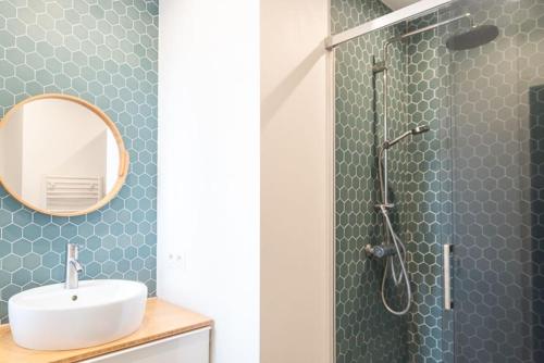 une salle de bain avec une douche avec un lavabo et un miroir dans l'établissement Appartement Cosy 1 bedroom Levallois-Perret, à Levallois-Perret