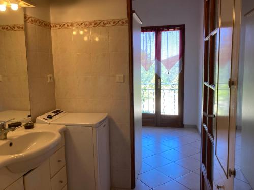 a bathroom with a sink and a washing machine at Maison au Colorado Provençal in Rustrel
