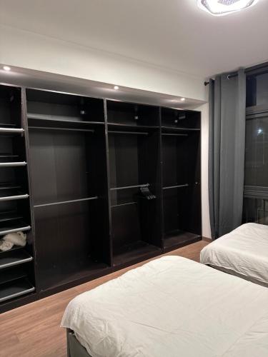 a bedroom with two beds and glass closets at Aura Apartments CFC in Cairo