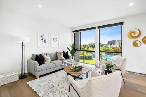 a living room with a couch and a table at Sands Coastal Villa Close to Pool, Beach and Golf in Torquay