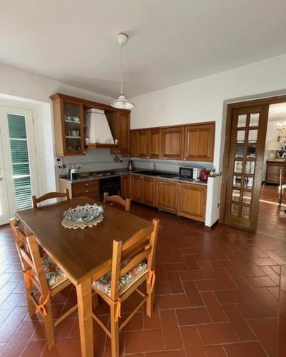 a kitchen with a wooden table and chairs in it at Appartamento in villa - Maria Grazia in Scarperia