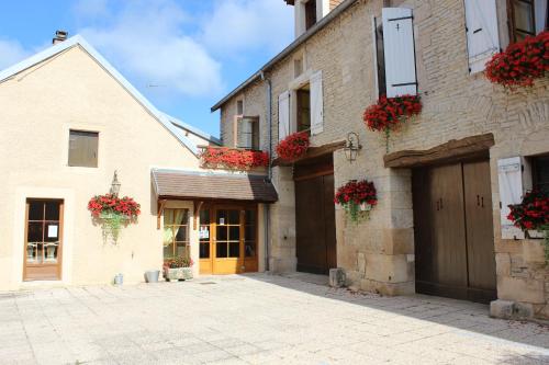 a building with flower boxes on the side of it at Hotel le Vauxois in Vaux-sous-Aubigny