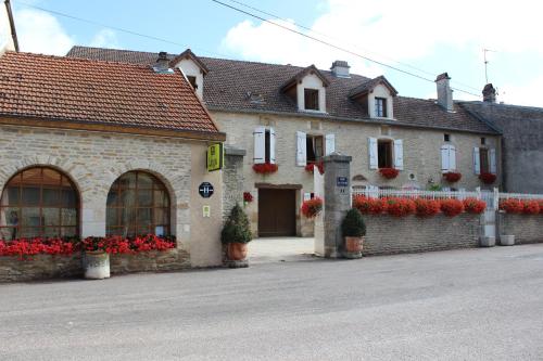 a building with red flowers in front of it at Hotel le Vauxois in Vaux-sous-Aubigny