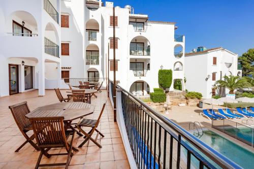 a balcony with tables and chairs and a swimming pool at Flipflop Surfing Playa in Santa Ponsa