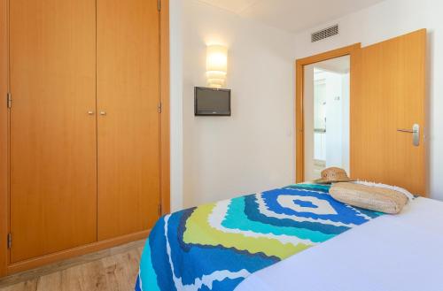 a bedroom with a bed and a tv on the wall at Flipflop Surfing Playa in Santa Ponsa