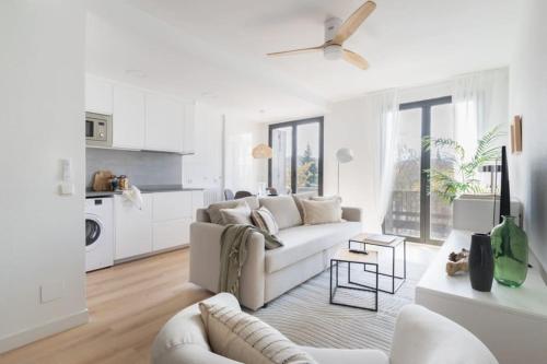 a white living room with a couch and a table at Apartamento La Nuez by Clabao in Pamplona