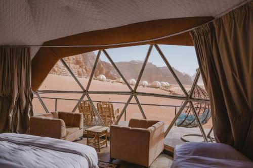 a bedroom with a view of a beach from a tent at Hasan Zawaideh Camp in Wadi Rum