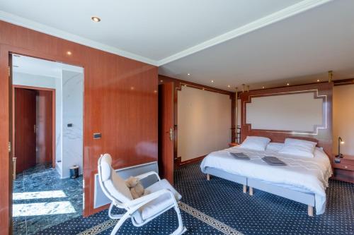- une chambre avec un lit et deux chaises blanches dans l'établissement Le Navire - Appt vue mer à 50 m de la plage, à Mers-les-Bains