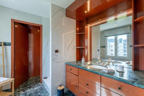 une salle de bain avec un lavabo et un miroir dans l'établissement Le Navire - Appt vue mer à 50 m de la plage, à Mers-les-Bains