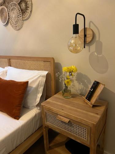 a table with a vase of flowers and a lamp at Casa da vila in Faro